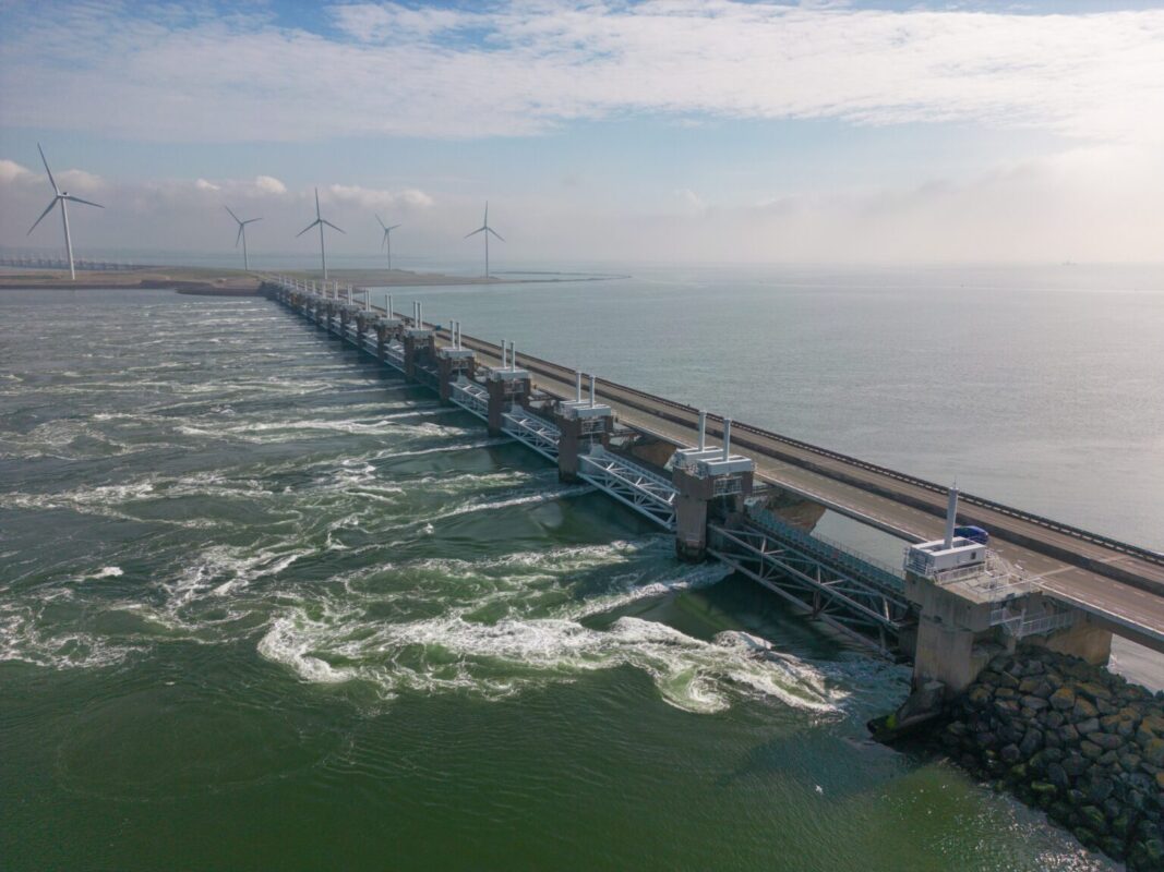 De Oosterscheldekering met windmolens op de achtergrond.