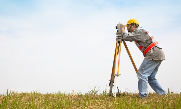 Landmeter in het veld ter illustratie van de ondersteuning Leica AP20 AutoPole voor TPS Online in dg DIALOG